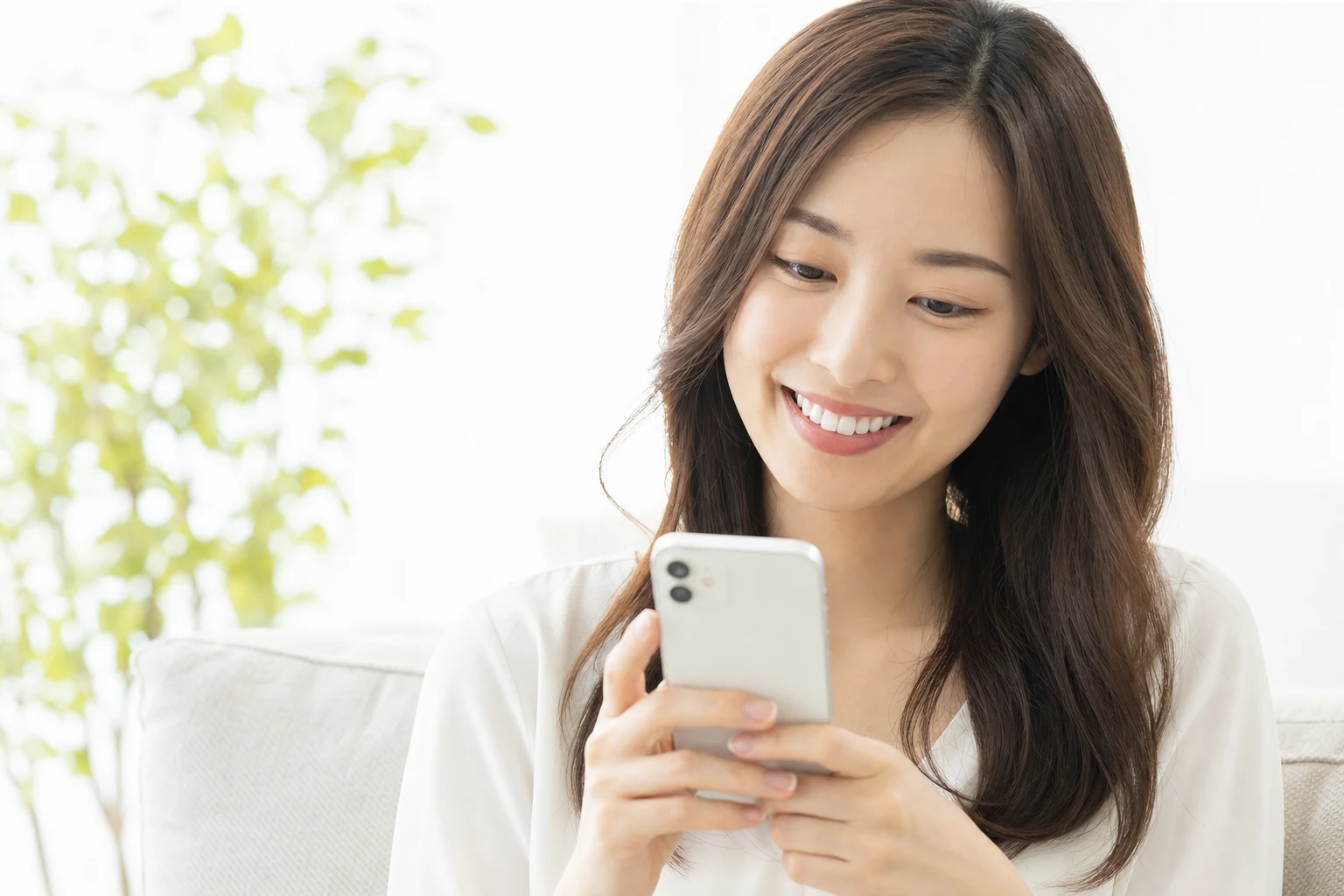 スマートフォンを見ながら笑顔を見せる女性